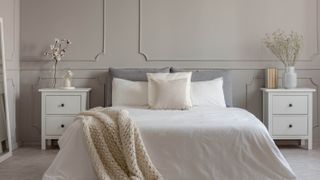 A hybrid mattress placed on a box spring in a grey and white bedroom