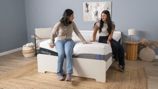 Two testers for Tom's Guide sat on the Nectar Luxe mattress and smiling at each other