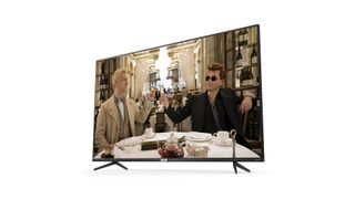 The TCL 55RP620K TV on a white background. On screen are two men in suits at a table in a restaurant.