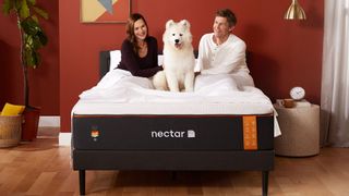 Nectar Premier Copper Mattress review main image shows two people and a dog enjoying the mattress