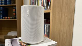 Sonos Era 100 in white colour sitting on shelf in test room