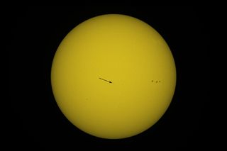 An exceptionnal image showing the chinese space station Tiangong crossing the disk of the Sun on december 31 2021. The arrow shows the position of the station due to its very small apparent size. On the disk of the Sun we can also see sunspots (on the right the sunspots AR2916). Image taken by the author from Seine et Marne with an amateur telescope. Arrow drawn by the author.