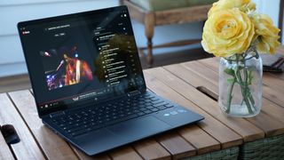 HP Elite Dragonfly Chromebook on wooden table next to yellow flowers in a jar