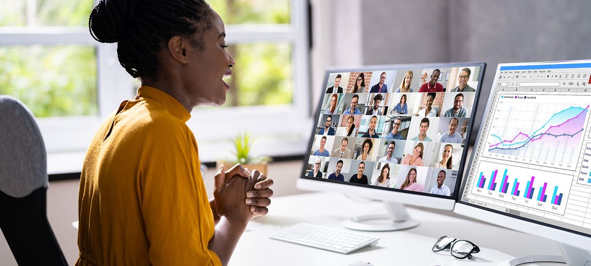 Woman using two monitors during meeting