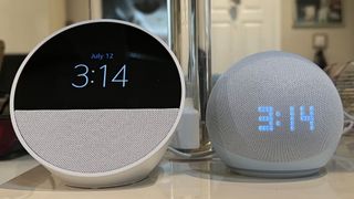 Echo Spot next to Echo Dot with Clock on nightstand