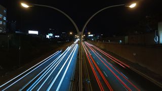 Night time photo showing traffic streaks on two-way traffic.