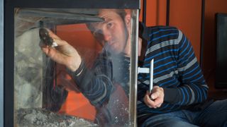 Man cleaning fireplace glass