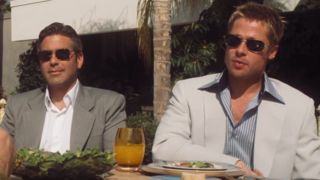 George Clooney and Brad Pitt sitting next to each other wearing sunglasses in Ocean's Eleven.