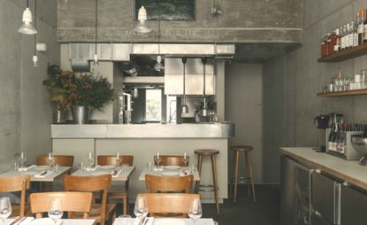 Silver &amp; grey restaurant interior with wooden chairs &amp; tables