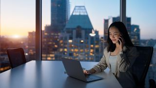 asian woman using laptop at business table