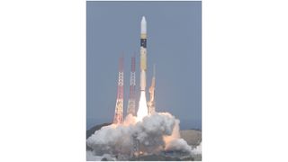 a yellow and white rocket launches into a blue sky