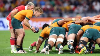 Australia scrum half, in yellow and green, puts the ball into the scrum during Australia vs Wales.