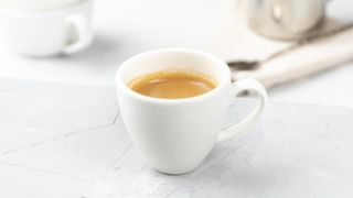 A cup of espresso on a stone worktop representing how to make espresso