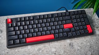 A black Lemokey X5 wired mechanical keyboard with red and black keycaps