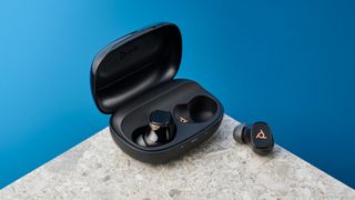 A pair of black and gold HP Poly Voyager Free 20 wireless earbuds