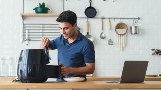 Man using an air fryer in kitchen