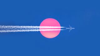 An airplane with contrails across the surface of a pink hued sun against a blue sky.