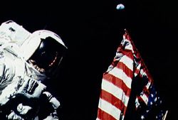 In this Apollo 17 onboard photo, Mission Commander Eugene A. Cernan adjusts the U.S. flag deployed upon the Moon during the December 1972 lunar landing mission, which marked the last of NASA's Apollo Moon landings.