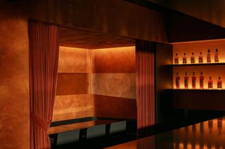 Private dining area at Ama Bar, hidden by a velvet orange curtain