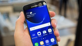 Samsung Galaxy S7 in hand, showing display