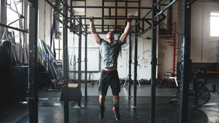 Man performing a pull up in the gym