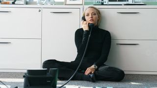 Amanda Seyfried as Elizabeth Holmes sitting on the floor while answering the phone in The Dropout