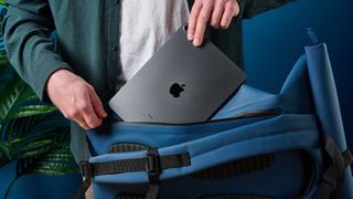 A photo of the D-Robe Roll-Top backpack having a laptop slid into the rear compartment