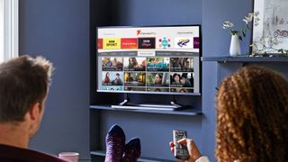 A couple watching a 32-inch smart TV in blue room