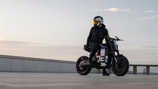 A man in full motorbike gear on a Super73 electric bike looks over his shoulder