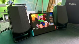 Majority DX30 Bluetooth speakers next to a Nintendo Switch OLED playing Lugi&#039;s Mansion 2 HD. 