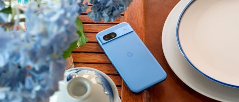 The blue Google Pixel 8a on a tea tray with blue hydrangeas above it