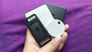 Various Google Find My Device Bluetooth trackers from Chipolo and Pebblebee held in one hand.