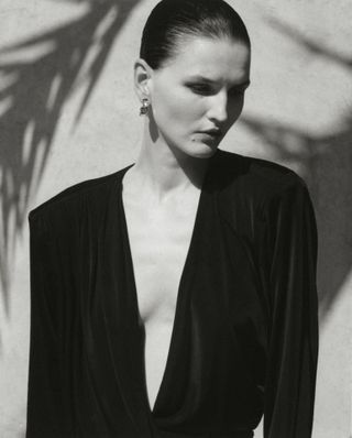 Model wears black against backdrop of Moroccan hotel