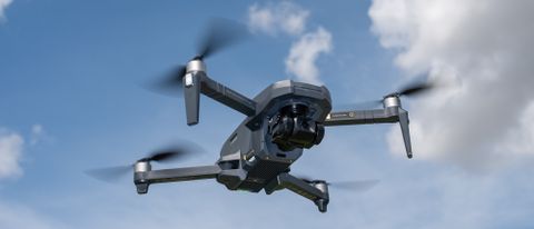 A Holy Stone HS720R drone in flight against a blue sky