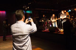 Man taking picture of group in dark venue