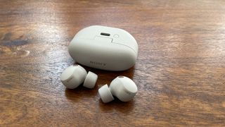 Sony WF-1000XM5 earbuds outside the closed charging case