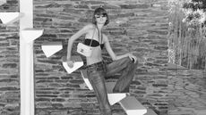 Woman in Celine shirt and bikini and sunglasses on stairs