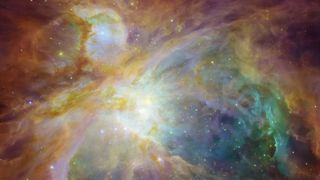 A Hubble Space Telescope image of the Orion Nebula shows swirling clouds of orange, blue, white and green dust in a field of twinkling stars