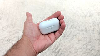 The 1More Evo wireless charging case being held in hand