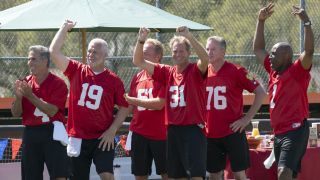 Contestants on The Golden Bachelorette Season 1 cheer while wearing red jerseyes on a group date.