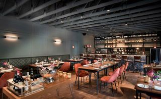 The Peech Boutique Hotel dining area decorated with many tables and chairs. There bar is on the right.