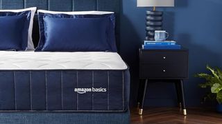 The Amazon Basics Signature Hybrid Mattress in a dark blue bedroom