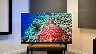 Philips OLED909 OLED TV on wooden hi-fi bench showing underwater image on screen