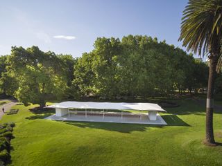 Aerial view of the white pavilion, surrounding trees, grassed lawn and blue sky