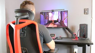 A person sitting in the Herman Miller Vantum gaming chair while playing games at a desk