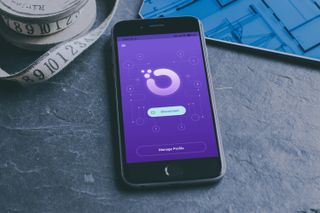 Bästa VPN för Android: Orchid VPN körs på en mobil som ligger på ett mörkgrått skrivbord.