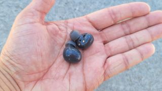 Black Samsung Galaxy Buds 2 resting in a user's hand