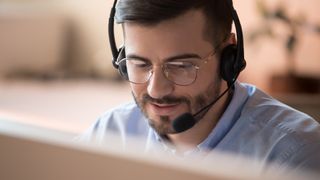 A man in an office talking on a headset