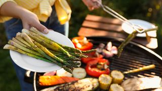 Woman cooking vegetables on a grill