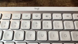 The Logitech MX Keys Mini for Mac keyboard on a wooden desk